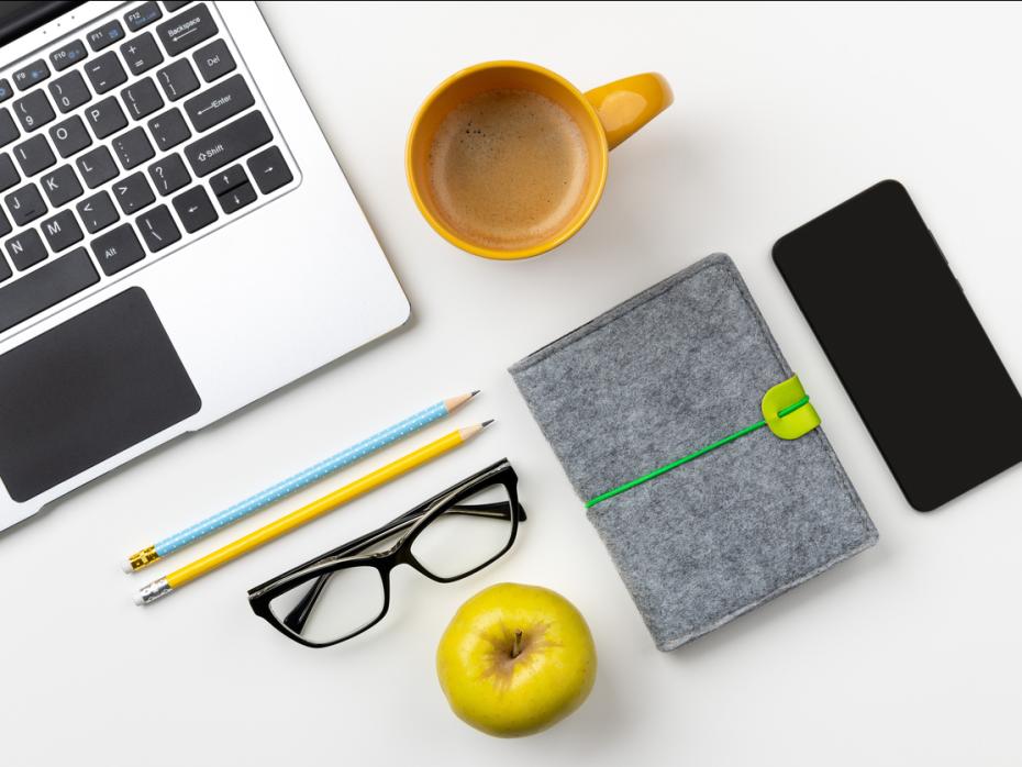 A laptop, coffee and apple depict an unrealistic working from home set-up