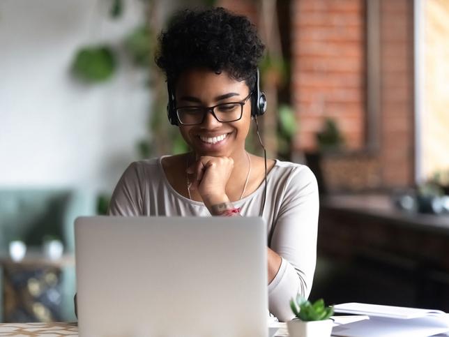 Young African women wearing headphones in a university cafe - reconnecting after the pandemic