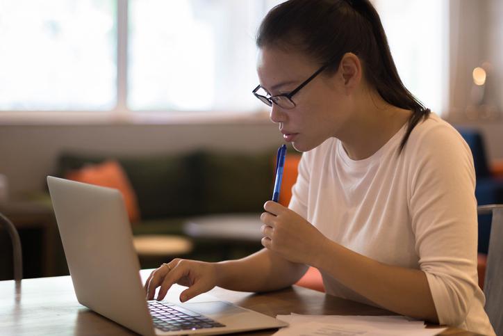 Asian woman looking at laptop