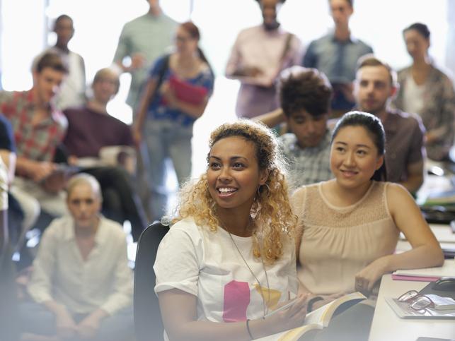 Students at university looking to the left of the camera towards an off-screen instructor