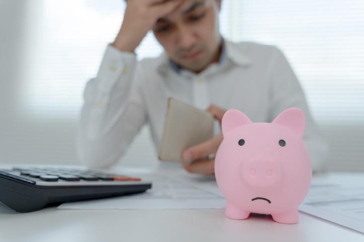 Young Asian man with piggy bank