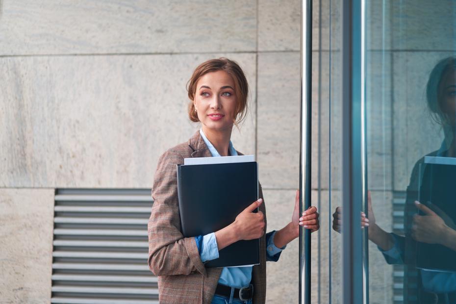 Woman opening a door to her university building