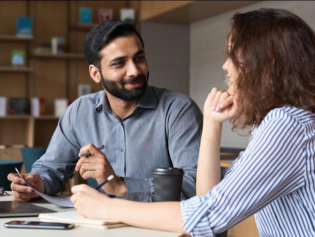 Two people sit and discuss a CV