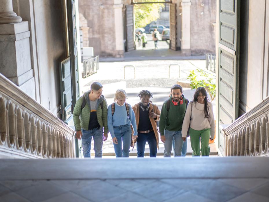 Students walking up a staircase in an old university building