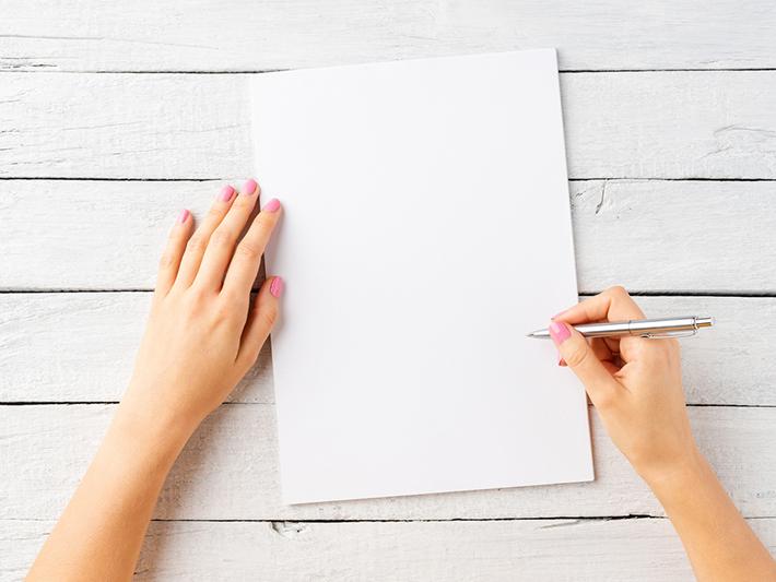 Female hands with a pen and a blank page