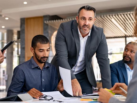 Colleagues debate over an office table