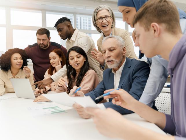 A group of people brainstorm around an office table