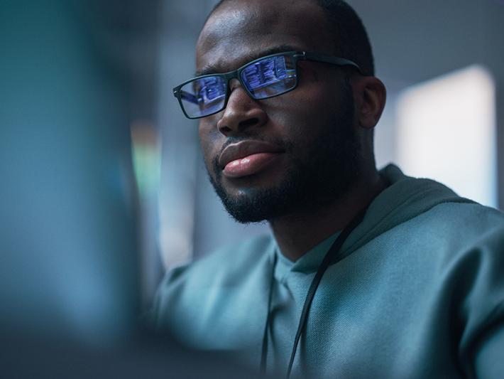 Black man looking at computer screen