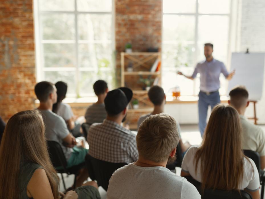 Male speaker giving presentation at a university to a room full of students