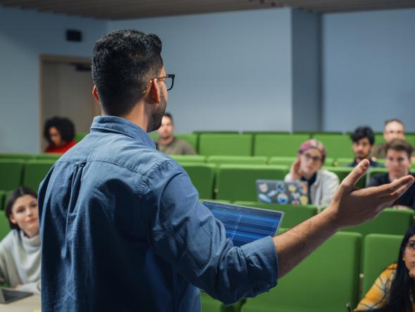 A lecturer speaks to a group of students