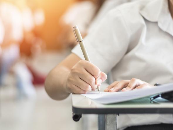 A student uses a pen to take a test