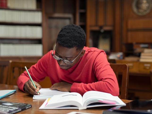 A student in the library makes notes