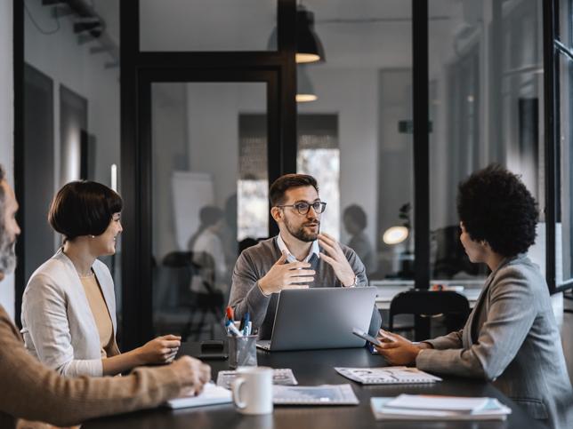 A group of people work around an office table