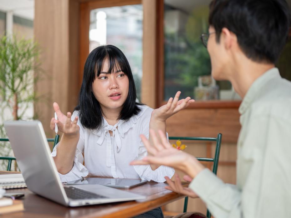 Student speaking to a teacher in front of laptop