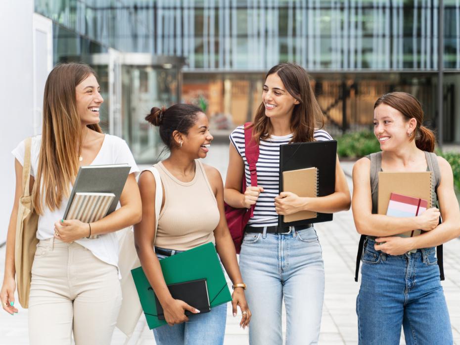 Students standing and chatting outside of a campus building