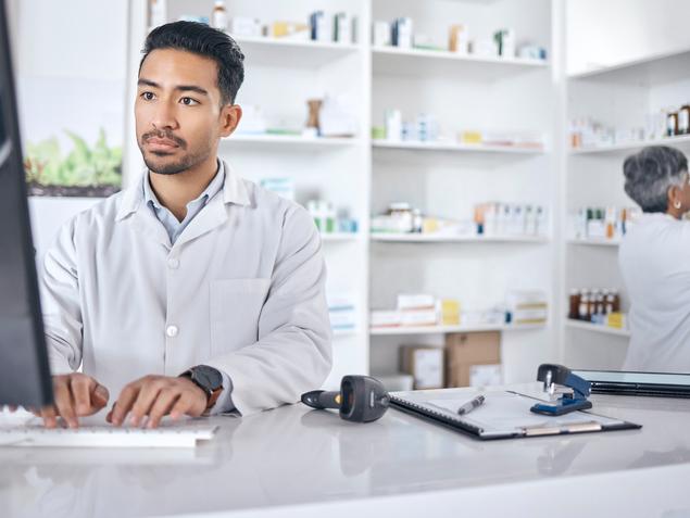 A pharmacist works on a computer