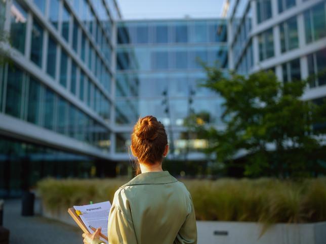 A woman surveys a building 