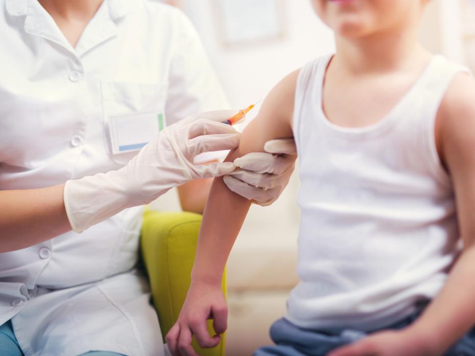 Boy receives immunisation from medical professional.