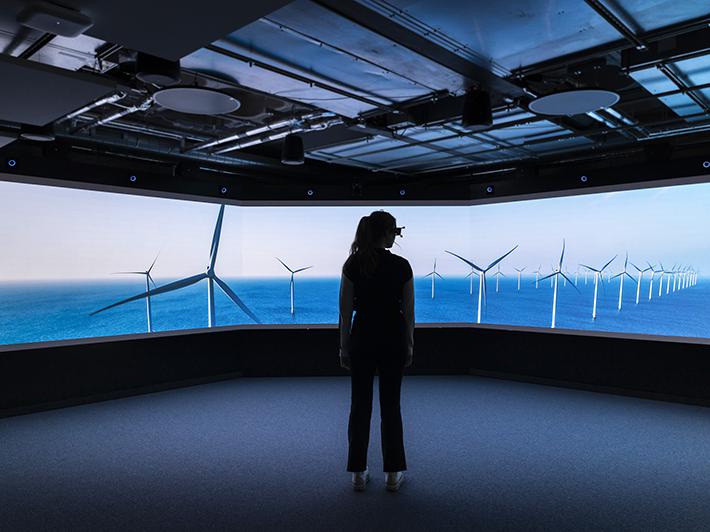 Woman in VR headset against image of wind farm