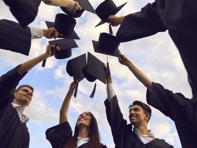 A group of PhD students touch mortarboards