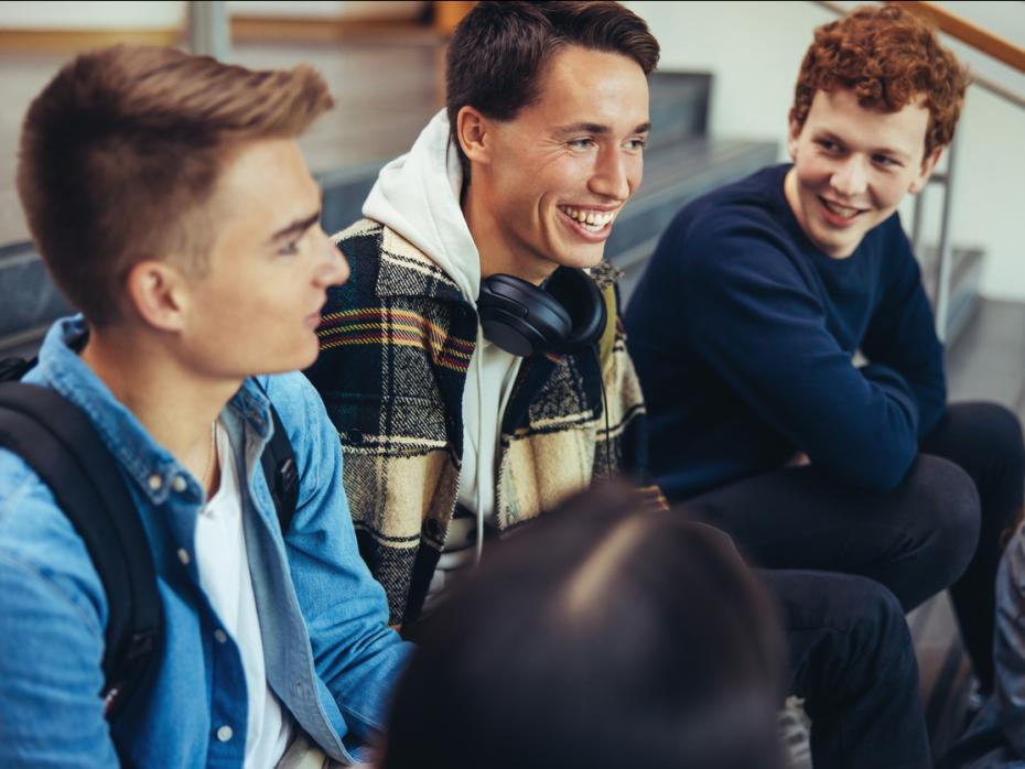 Three male students laughing and chatting