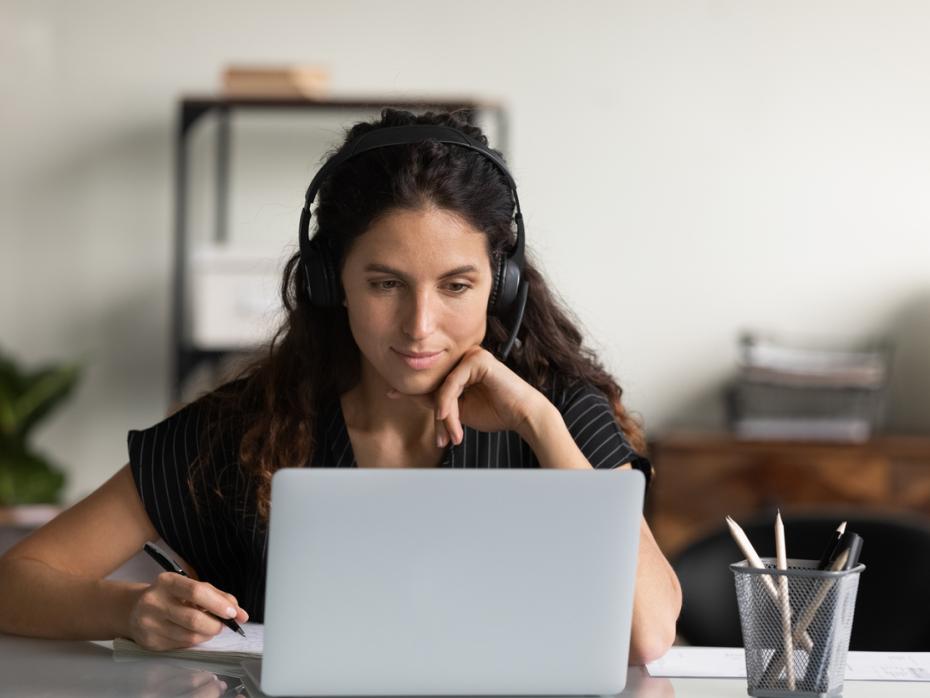 A student at her laptop with earphones on