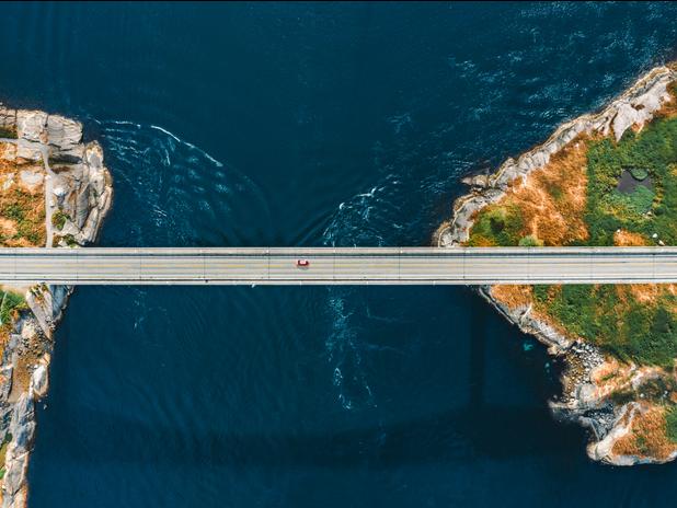 A car driving on a bridge across the sea