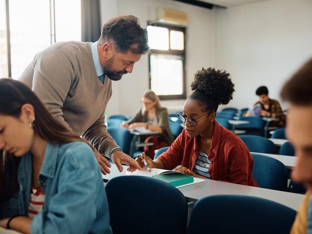 A professor helps a student in class