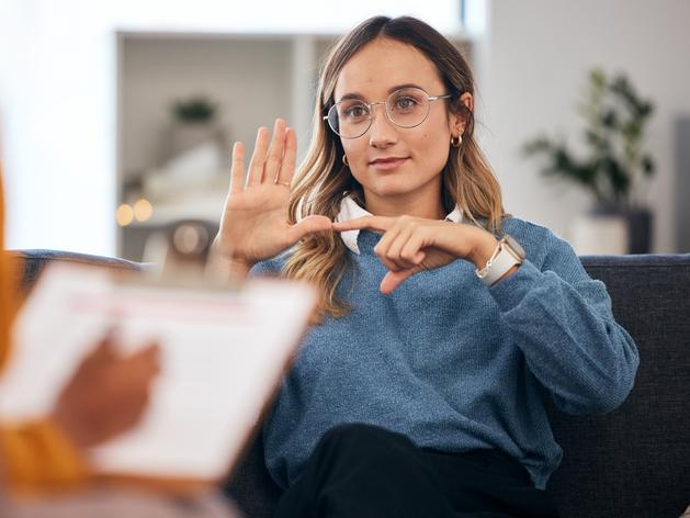 A young woman uses sign language