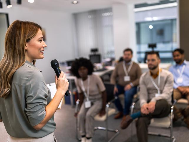 A woman gives a talk to a room of colleagues