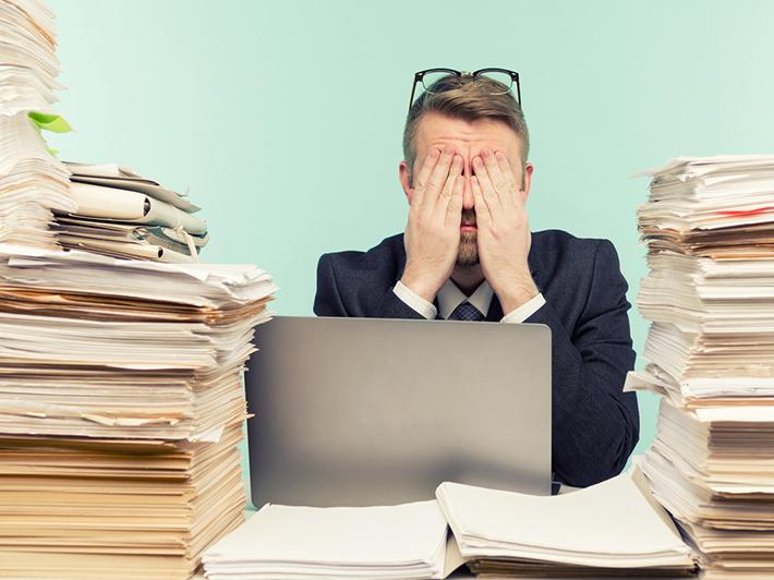 Man sitting among piles of papers