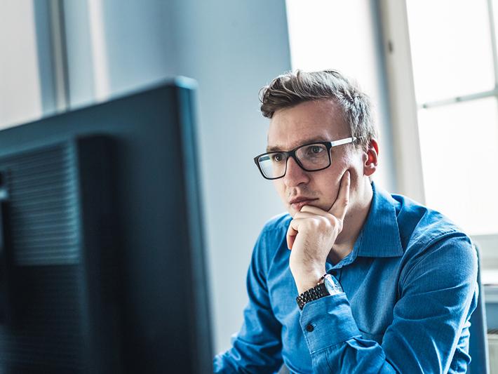 Male student concentrating at laptop