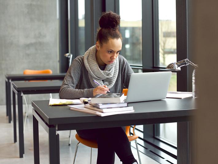 Student writing in library