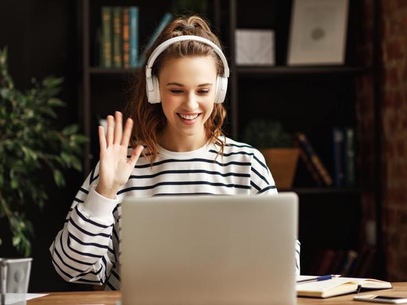 A cheerful student waves hello on a Zoom call