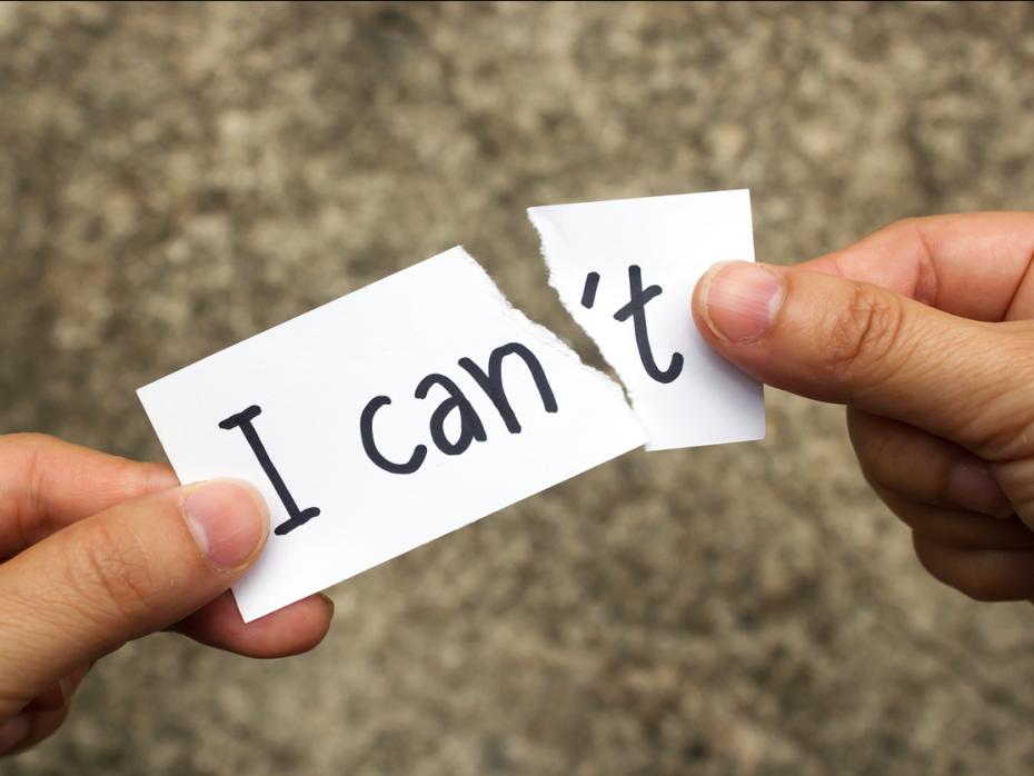 Hands tearing off the letter "t" from the word "can't "