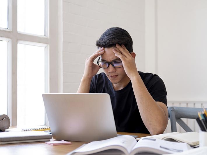 Asian student concentrating on laptop