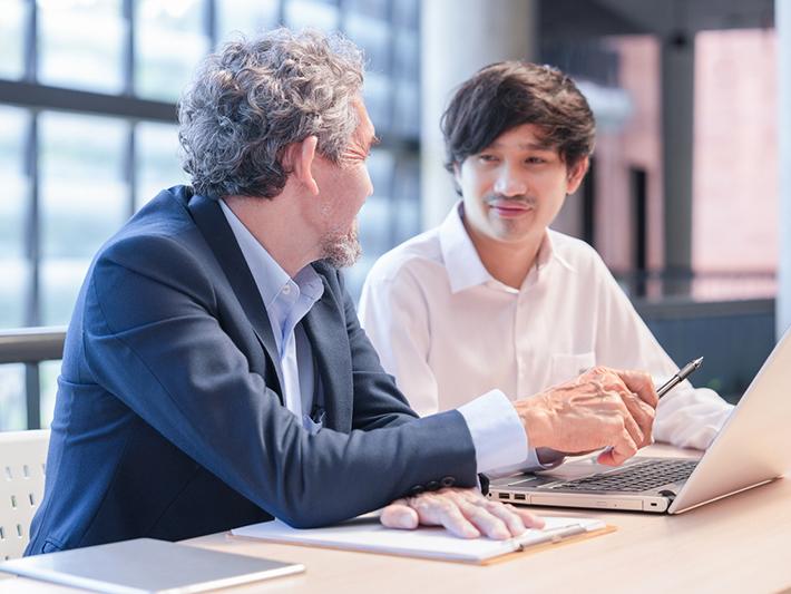 Professor talking to male Asian student