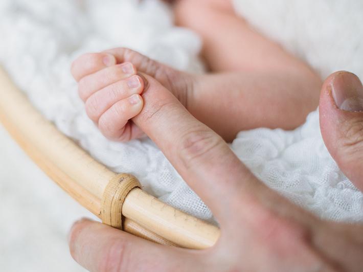 Newborn baby holding mother's hand