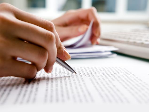 A close up of a hand working on a document