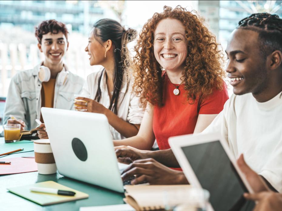 Students in a classroom smiling to camera