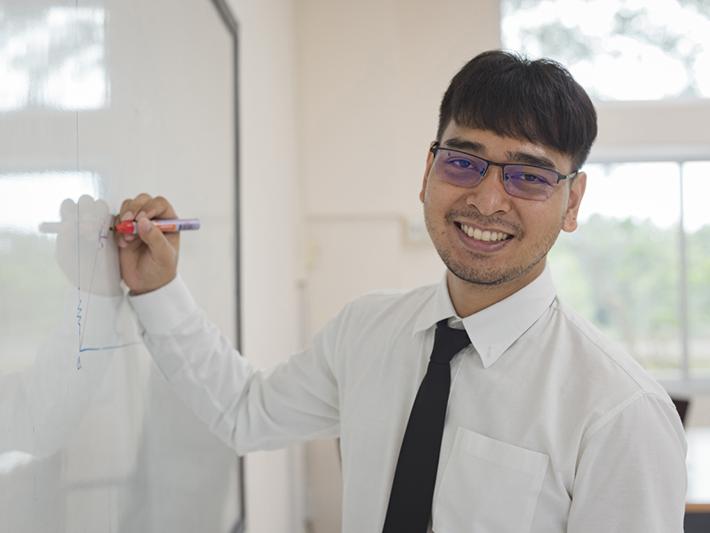 Young male teacher at whiteboard