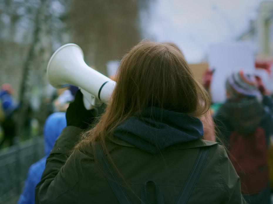 A woman holding a megaphone while protesting