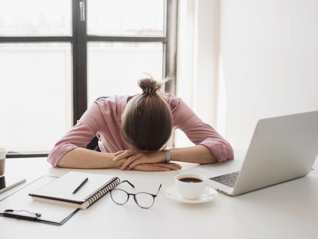 A woman puts her head on the desk
