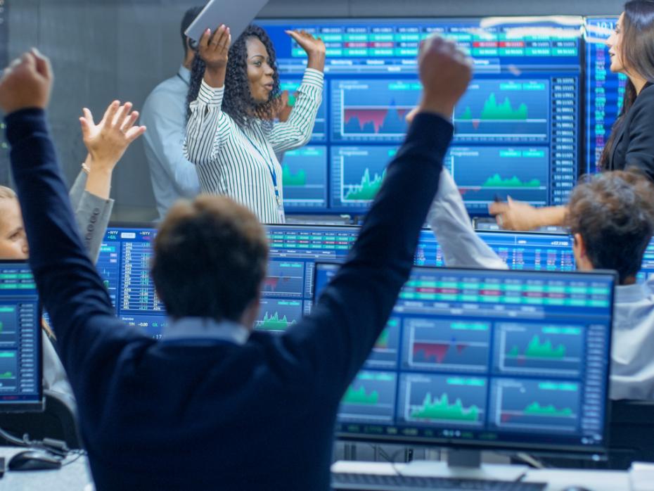 Traders at their computers celebrating