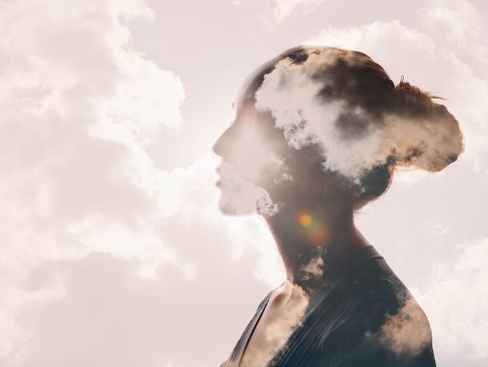 Woman with head in clouds, calm concept