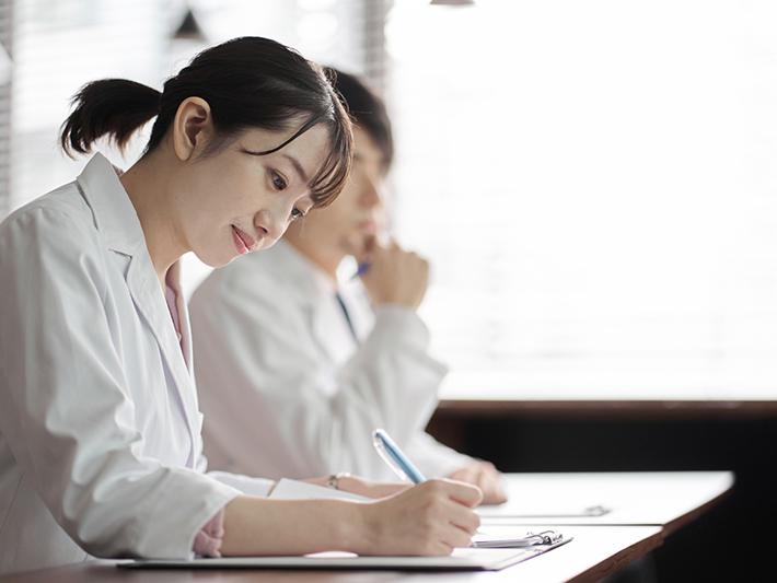 Young female Asian university student in white coat