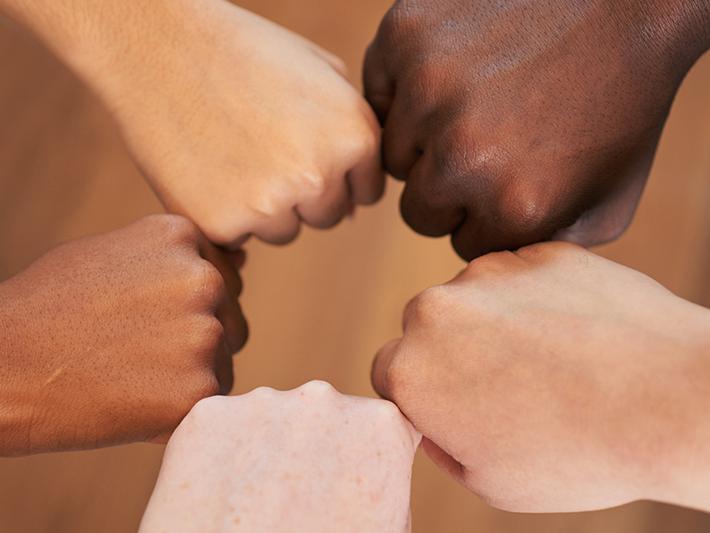 Multiracial hands in fist bump circle