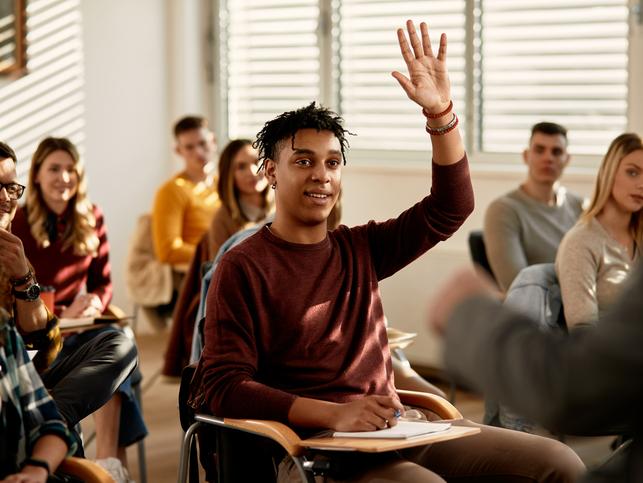 A student raises a hand in a classroom