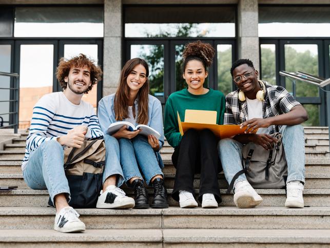 A happy group of students pose on a flight of steps