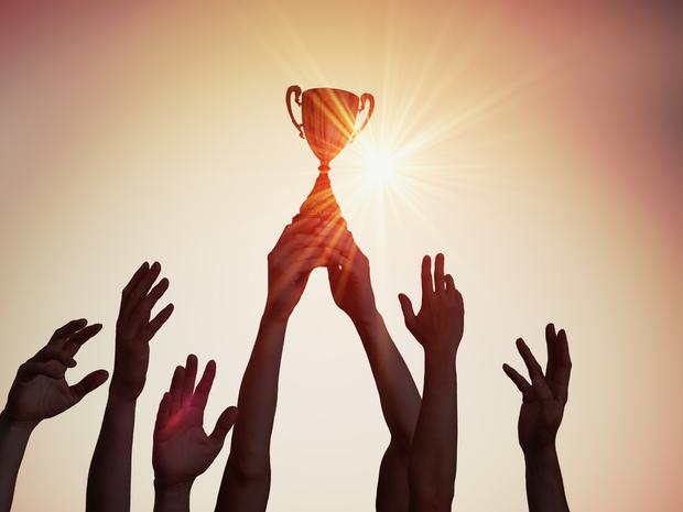 Hands hold a trophy aloft